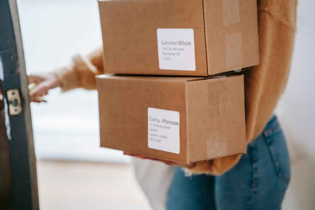 Person holding a parcel in front of a door, representing a mailing address for virtual office for GST registration.